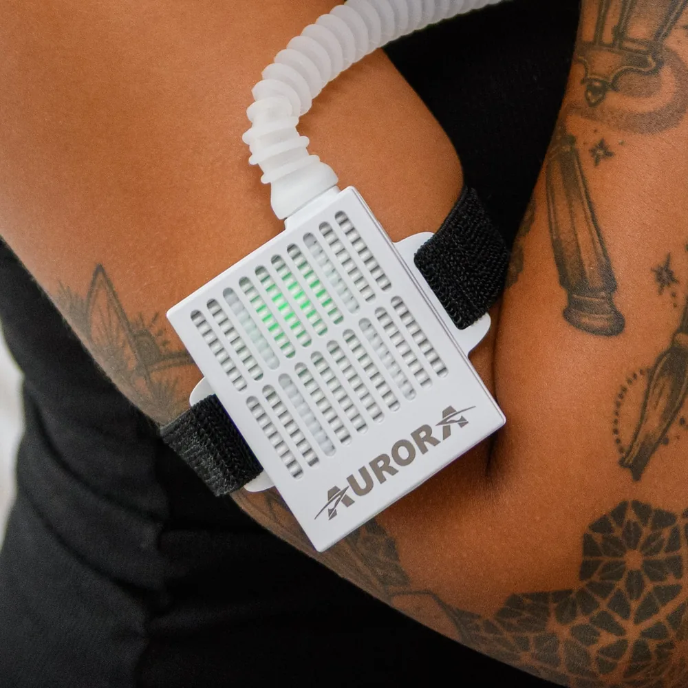 The Opti+ MiniPAP air blower strapped to a woman's upper arm, showing how small it is